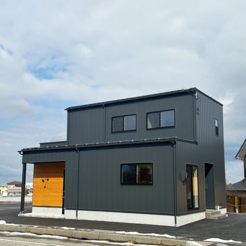 外壁にはマットブラックの金属サイディングを選ばれました。そして、店舗併用住宅なので扉が二つ！写真は店舗側の入り口になります。玄関ポーチには杉の板張りでアクセントをプラス！