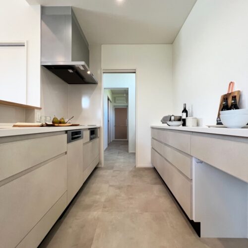 キッチンとカップボードは、タカラスタンダードさんのオフェリア。  お色は、真っ白ではなく少しだけベージュがかった優しいカラーです。  床には、モルタル柄のサンゲツさんのフロアタイルを。（フロアタイル：サンゲツIS-2073-B）