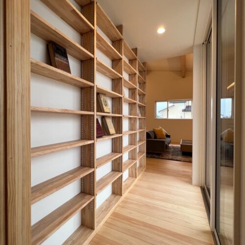 リビングの扉を開けると目の前には大工さんお手製の造作棚！  本棚かなと思われますが、なんとこちらはCD用の収納棚♪圧巻です( ﾟДﾟ)  向かい側はテラスへと出れる大きな窓。圧迫感もありません！     無垢フローリング：ひのき