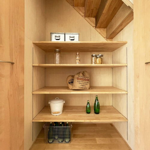 ダイニングテーブルの横には、階段下を利用した食品庫。  可動棚がついておりますので、ストックしたい物の大きさに合わせ、自由に棚を上下できます。