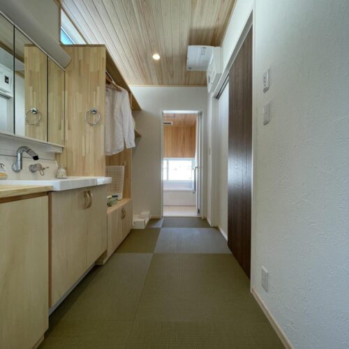 ランドリールーム兼洗面脱衣室は、畳タイルにひのきの板張り天井で和の雰囲気に♪  壁に作り付けられた棚は大工さんのお手製です。