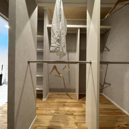 グレーのクロスで落ち着いた雰囲気のファミリークローゼット。  たくさんのパイプが取り付けられているので干した衣類をそのままハンガー収納することができます(^o^)／  ランドリールームと繋がっているので家事の時間もグッと短縮できますね♪