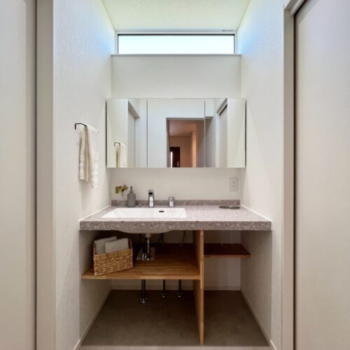 洗面所は、キッチンとサンルームの間に造りました。  アイカの洗面台の下には、洗面用品などを収納できるような造作棚を。  お子さんの踏み台なども下にしまっておくことができます。