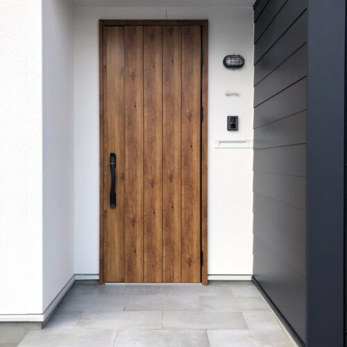 木目調の玄関ドアは空間をあたたかみのある雰囲気にしてくれます。  照明にはマリンランプをアクセントとして付けています。