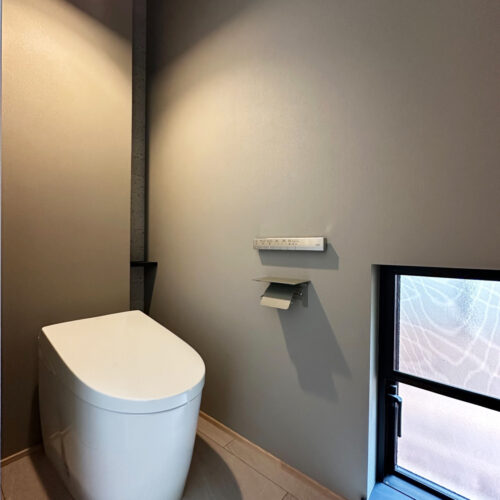 グレーのクロスでスッキリとしたトイレ空間。  背面の目隠し収納にもこだわりました。