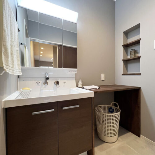 キッチンスペースを抜けると洗面脱衣室に繋がります。  既製品の洗面台の横にカウンターを造作し、広々使える仕様に♪  壁には埋め込みニッチを施工しスッキリとした印象になりました(^_-)-☆     洗面台：リクシル ピアラW750 LM2H/三面鏡