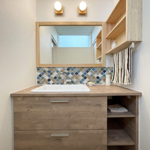 洗面台はTOTOのドレーナ。カウンター部分が広く、ゆったりと使えるのがいいですよね♪  木目調がお洒落な洗面台は、コラベルタイルとの相性もバッチリ♡収納棚と鏡の枠は大工さんお手製です！