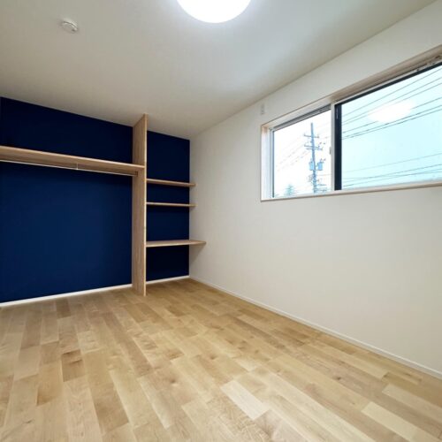 アクセントクロスに深いネイビーとお色を選ばれた、かわいい子供部屋。（アクセントクロス：ルノンRF8250）  アクセントクロス側には、造作でオープンタイプの収納（左側）と勉強机（右側）としても使えるカウンターを造りました。