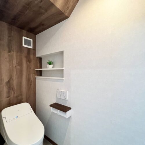 洗面スペースの向かいにはトイレを設けました。  こちらは階段下を有効活用！  背面と天井に木目調のクロスを貼り、圧迫感を感じさせない空間に♪     木目調クロス：サンゲツ FE74194