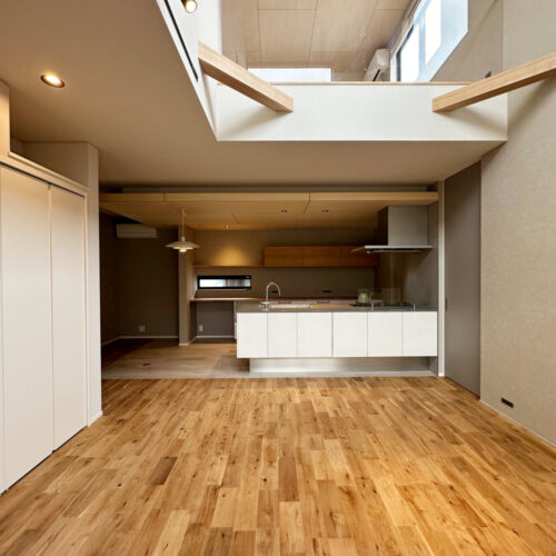 開放感感じる吹き抜けＬＤＫ。  グレーのクロスに木目の組み合わせが落ち着く空間。