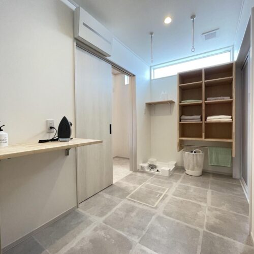 脱衣室では洗う→干す→仕舞うの一連の流れができるように設計しました。  折りたたみ式のアイロン台やタオルの収納棚は大工さんお手製です。