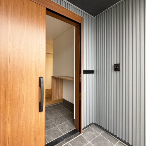 玄関ポーチには、アクセントとしてシルバーのガルバリウム鋼板に。（ポーチ以外の外壁はブラックのガルバリウム鋼板）  玄関ドアは、ＹＫＫの玄関引戸（コンコード）を選ばれました。