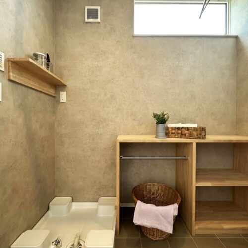 洗濯機横にはスペースに応じて大工さんが収納棚を造作しました。  下はタオルやバスマットなどを収納し、カウンター部分では乾いた衣服をたたんだりアイロン台として活用！