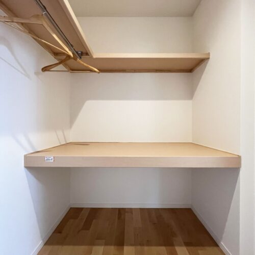 ファミリークローゼットには枕棚と中段、パイプハンガーを造作しました。  パイプハンガーは乾いた衣服をそのままハンガー収納として、奥の中段には、衣装ケースに入れた季節物の洋服や布団などを収納できます。