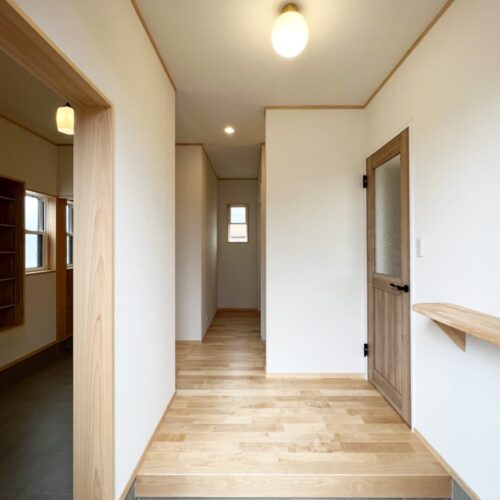 ナチュラルな雰囲気の玄関。  床材は色合いの優しいカバザクラを選ばれました。左側には、家族用のシューズクローゼットと土間が続きます。  玄関上がって右側の扉はリビングへ。  来客があっても、リビングの中が見えないのはうれしいですよね(*^^*)