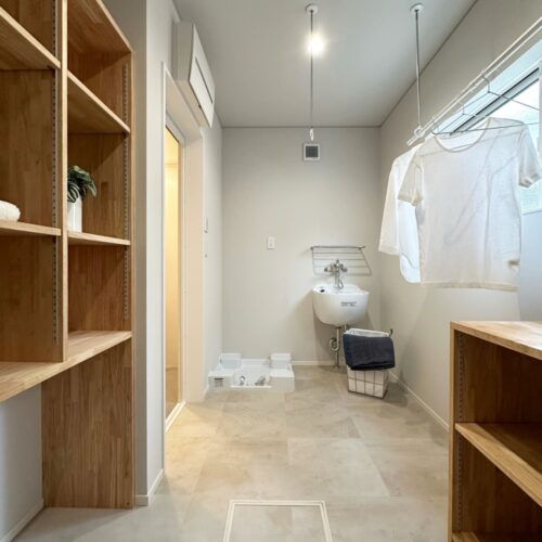 4帖の広さがある、サンルーム兼脱衣室。  物干し竿2本分のホスクリーンがあり、また造作の収納棚も造りました。  洗濯機の横にはスロップシンクを設け、洗濯物の予洗いや大物を洗う時にもとても便利！