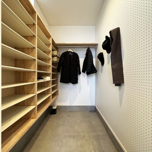 玄関の奥には、家族専用のシューズクロークがあります。  大工さんお手製の収納棚とパイプハンガーを取り付けました。  収納棚の反対側には有孔ボードを施工し、遊び心をプラス(*^^)v  帽子やストールなどを掛けるも良し◎傘を掛けるのもありかも～♪  オシャレなＫ様はどのように活用するのでしょうか( *´艸｀)