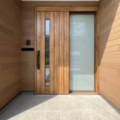 玄関引戸は、YKKのコンコードです。  引戸面と両側の壁面は、アクセントとして窯業系サイディング（ニチハ キャスティングウッド ナチュラルオーカーMG）を施工しました。  袖部分には乳白色のガラスを付けられたので、玄関の中に優しい光を取り入れてくれます(*^^*)