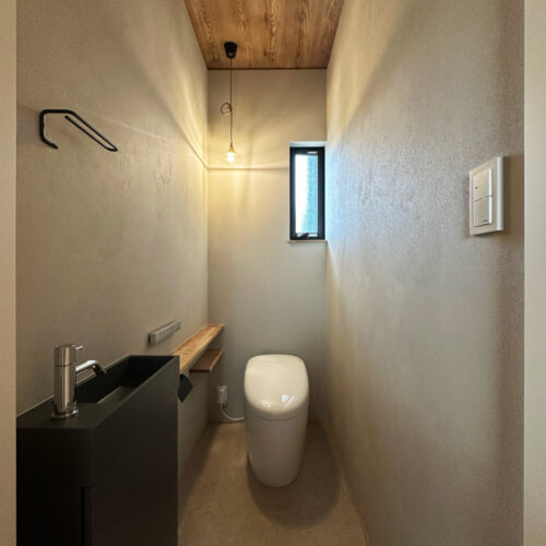 お客様をお迎えする事の多い１Ｆトイレには、  高級感のあるグレーの塗り壁調クロスと木目調のクロスを組み合わせて落ち着いた空間に仕上がりました。  片隅に添えたペンダントライトがまたお洒落♡