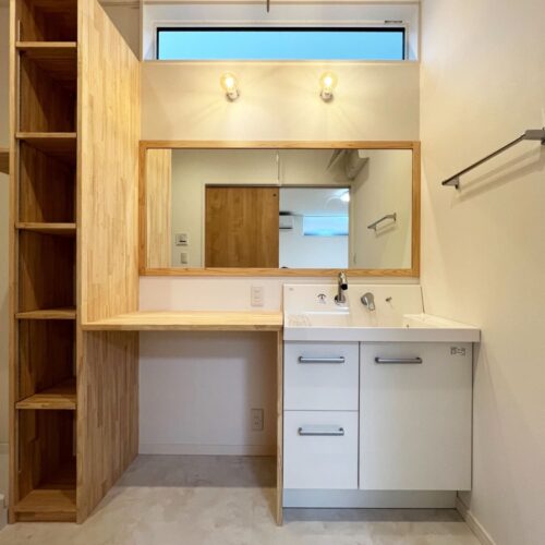 洗面台は既製品の洗面台の横にカウンターを造作し、広々使える仕様に。  朝の身支度時間も、洗面台が取り合いになりませんね♪  鏡の枠と収納棚も大工さんのお手製です。     洗面台：リクシル ピアラ（下台のみ）  照明：ODELIC／OL 251 715LC1