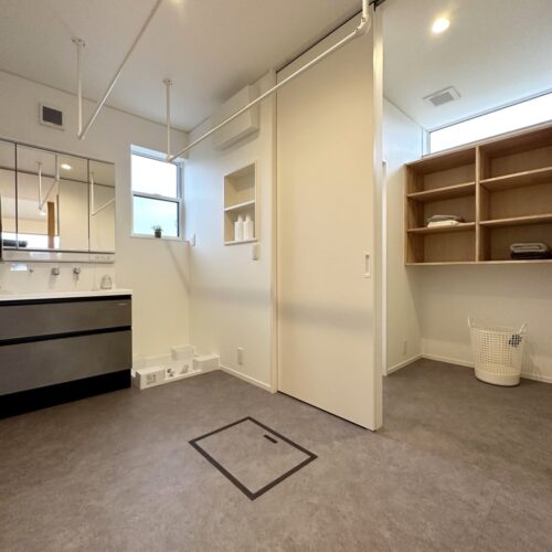 ユーティリティー横の扉を開けると脱衣室・お風呂に繋がる動線。  洗濯機横の壁には洗剤用のニッチを施工。スッキリとした印象に♪  洗濯後はすぐその場で干せるように、天井にパイプハンガーを取り付けました。  洗濯が楽しくなるかも～☆☆☆     洗面化粧台：タカラスタンダード エリシオ