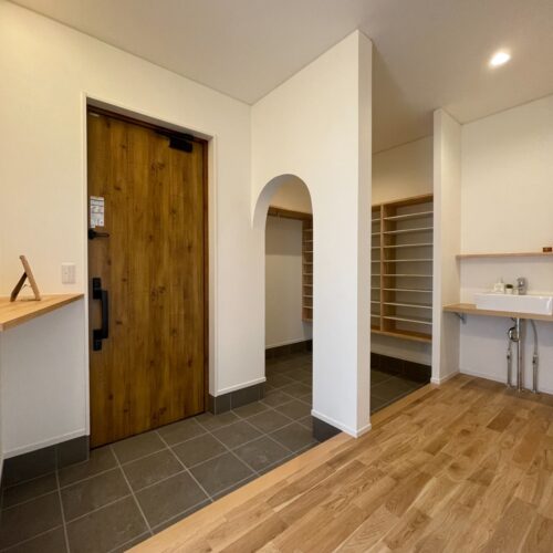  アーチ壁をくぐると大容量のシュークロ！家族みんなのアウターをかけても余裕のパイプハンガー付き♪  そして、シンプルだけど造って大満足の『ただいま手洗い』が身につく動線です。