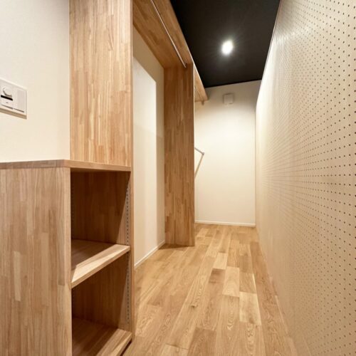 造作本棚の裏に、収納もでき有孔ボードでDIYも楽しめる空間を造りました。  オープンタイプの収納には、パイプハンガーをたっぷり付けられたので洋服もたくさん収納できそうです。