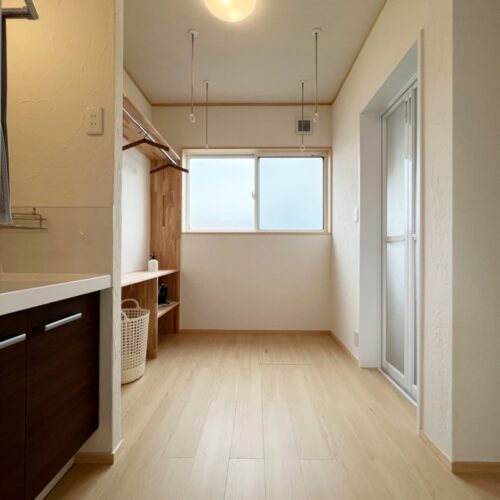 こちらは洗面脱衣室です。  雨の日には洗濯物も干せる様に、ホスクリーンを付けました。左側の造作棚にはパイプハンガーを付け、干した洗濯物をそのままかけておくこともできるのでとても便利！  床：サンゲツフロアタイル WD-922