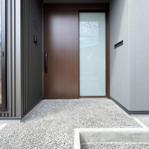 玄関ポーチの一部は、グレーの吹付けで仕上げました  シックな色合いでまとめた玄関ポーチはオシャレでカッコイイ印象に( *´艸｀)  軒天には埋め込み型の人感センサーを取り付けました！  近づくとパッと照らしてくれるので安全面はもちろん、安心感もありますね☆彡     玄関ポーチ土間：那智石 洗い出し仕上げ