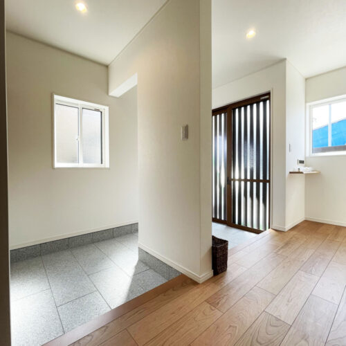 お客様をお迎えする玄関と、家族玄関に分けました。毎日使うところだから開閉が面倒な扉は設けず、仕切り壁が生活感を隠してくれるように設計。リビングへは2か所の入り口があるので、お客様はそのまま上がって左側へ（写真奥側）。家族は右側（写真手前側）へ進んでいきます。