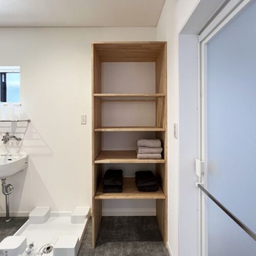 洗濯機置き場の横に設けた造作棚。  目を凝らしてよ～く見てくださいね♪2段目の板部分にパイプが見えます。  何のため？こちらはタオルストッカーの役割を果たします。  上にタオルを置いて、パイプの間から引っ張るとタオルが取れる仕組み。  使ってみるとビックリ( ﾟДﾟ)なんて便利なの～！？となりますよ(*´ω`*)  もちろん！大工さんのお手製です！