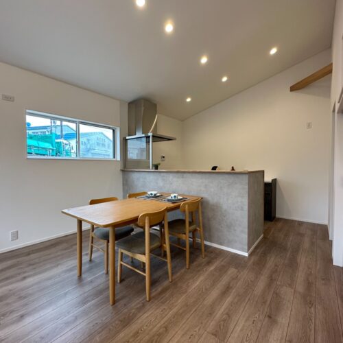 キッチン腰壁にはコンクリート調のクロスを貼りました。天井の照明もダウンライトで統一し、スッキリとした印象です。