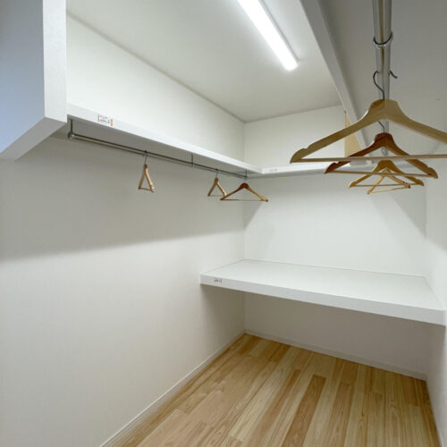 ウォークインクローゼットには、ぐるりパイプ付き枕棚が付いています。  ご夫婦の衣類がたっぷり収納でき、奥に見える中段には、衣装ケースに入れたものや、布団など大きなものを中段の上や下に収納することができます。