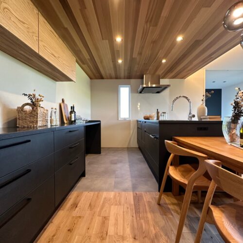  ブラックのオープンキッチンにカップボードも色味を揃えました。ブラックがとてもかっこよく、空間を引き締めます。  床、棚、天井のさまざまな木目もナチュラルで素敵。