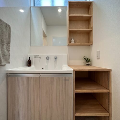 既製品の洗面台に大工さんお手製の収納をプラス！洗面横の壁にはキッチンパネルを施工し、水ハネ汚れの防止にも◎キッチンパネルならサッと拭くだけでお手入れが完了しますし、清潔感を保ちやすくなります(*^^)v