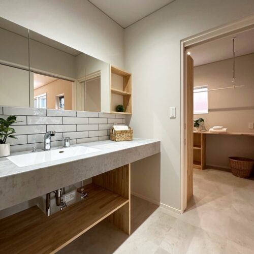 ホワイト系のタイルに、目地はダークグレーでお家の雰囲気にも合わせた洗面。  洗面台は、アイカのものを。  タイルの目地をグレー系にすることで、目地の汚れも気になりにくい利点があります。