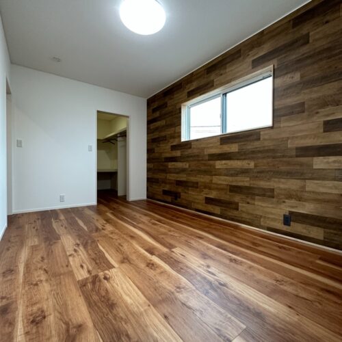 木目調のクロスがアクセントになり、落ち着いた雰囲気の空間になりました。クロスに合わせてコンセントの色もブラックに☆ウォークインクローゼットの入り口はオープンで物が出し入れしやすい動線になっています(^_-)-☆