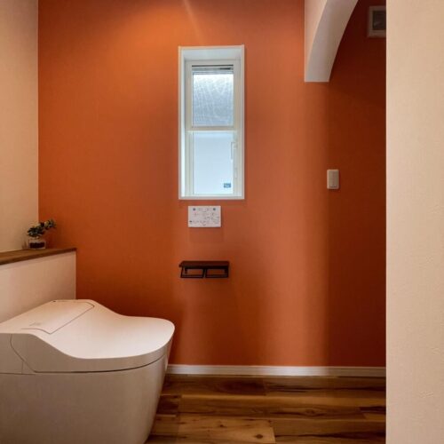 オレンジのクロスが目を惹く一階のトイレ空間。  アーチ型の壁の奥には何があるのでしょう？？     クロス：ルノン　RF-6284　　　フロアタイル：サンゲツ　WD933