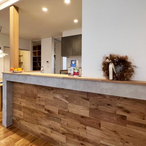 床材と同じく、キッチンの腰壁にもオーク材を貼りました。  木の温もりを感じつつ、グレーのアクセントクロスでモダンな印象にも★  まるでオシャレなカフェやセレクトショップのようですね( *´艸｀)  好みの雑貨やご家族の写真を飾り、お気に入りの場所にしちゃいましょう(^O^)／     腰壁アクセントクロス：リリカラ LL-7255