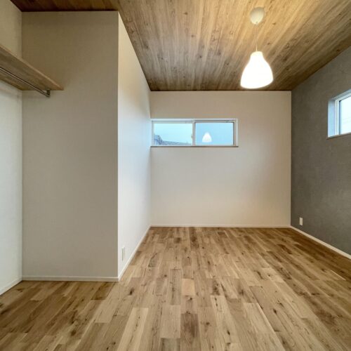 寝室は木目調の天井クロスと、グレーのアクセントクロスで自分好みに。  1Fにファミリークローゼットを設けたので、寝室には最小限のオープンクローゼットを。