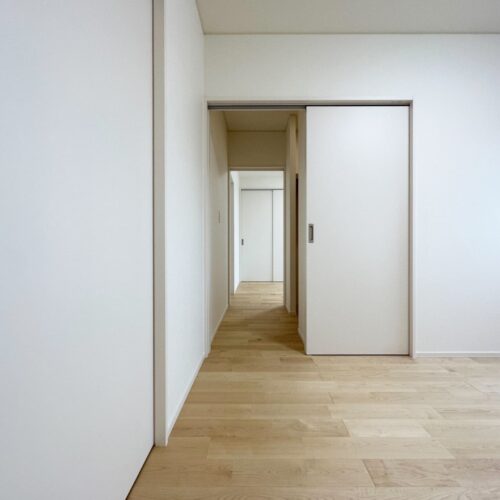 2つの洋室の間に共通のウォークインクローゼットを造ることで、そこを通して行き来できるようにしました。  写真は、ウォークインクローゼットの扉を両方開けている状態です。  個々の部屋ではあるけれど、すぐに行き来できることで安心感が生まれますよね(^^)  床材には優しい印象のカバを選ばれました。