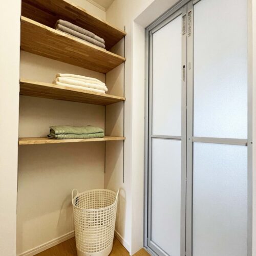 右側の扉がユニットバスの入り口。すぐ横に可動棚を取り付けました。パジャマやバスタオルが0歩で手が届くようになっています。床にはサンゲツのフロアタイル（GT-897）を使いました。