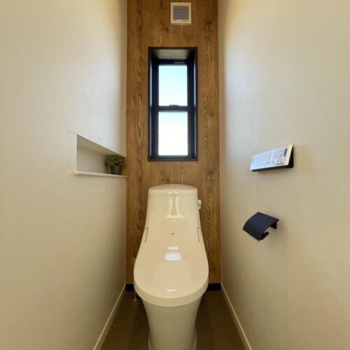 二階のトイレは、背面と天井を木目調のクロスに♪  窓枠とペーパーホルダーはブラックで統一し、お洒落なトイレ空間になりました。     トイレ：LIXIL　ベーシア手洗い無し  色：BW1（ピュアホワイト）  紙巻き器：河淳　SC-473-XK  背面クロス：RE-51323
