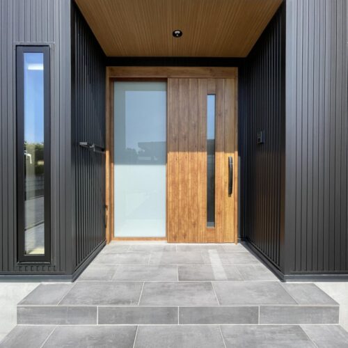 玄関タイルは名古屋モザイクのコットメントを馬目地貼りに、木目調の軒天はニチハのティンバーベージュ色を選ばれました♪  ブラックの外壁にマキアートパインの玄関ドアが映えますね～( *´艸｀)
