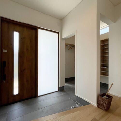 玄関ドアは袖ガラス付を選ばれたので、玄関の中はとっても明るい！  家族は奥のシューズクロークに靴をたくさん置けるので、お客様が来られてもいつもキレイな玄関を保つことが出来ます(*^^*)  玄関ホールには、くるみの床材を選ばれました。
