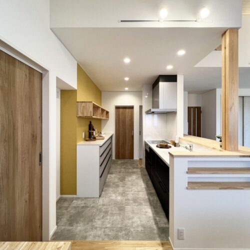 キッチンはTOTOのミッテ、カップボードはLIXILのシエラを選ばれました。  キッチンのネイビーブルーのお色と、カップボード面のアクセントクロス(サンゲツ：FE74628)の黄色がグッとくる組み合わせ…(*´▽｀*)  キッチンの奥の扉は、洗面脱衣室・お風呂・サンルームへと繋がっています。