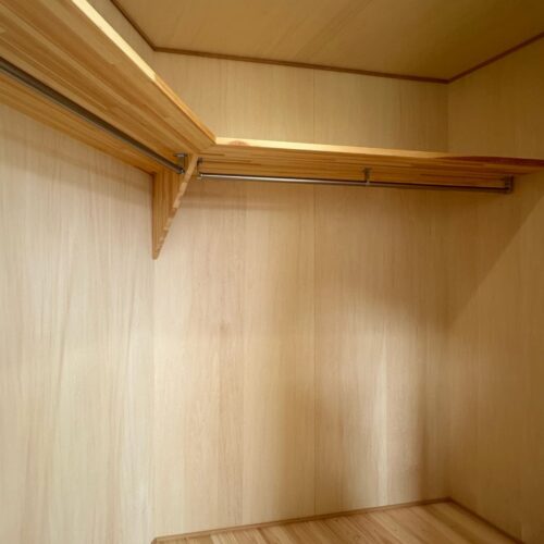 パイプハンガーと枕棚を造作したクローゼット。寝室のクローゼットは掛ける収納のみでスッキリと。