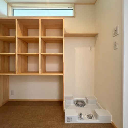 脱室には洗剤置き場と棚を造作。棚の下はあえて収納場所を設けずに、洗濯かごを置ける設計に。