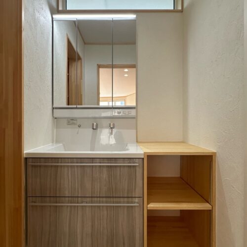 洗面台はタカラスタンダードのエリシオ。扉カラーはキッチンと同じタイプを選ばれ、お家全体の統一感をプラス。洗面台の横にはプラスで収納できる棚を造作しました。