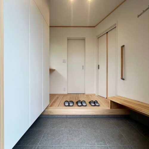 ひのきと漆喰壁に包まれる心地良い玄関。ベンチを造作したので、靴の脱ぎ履きもしやすく、買い物した荷物の一時置き場としても◎